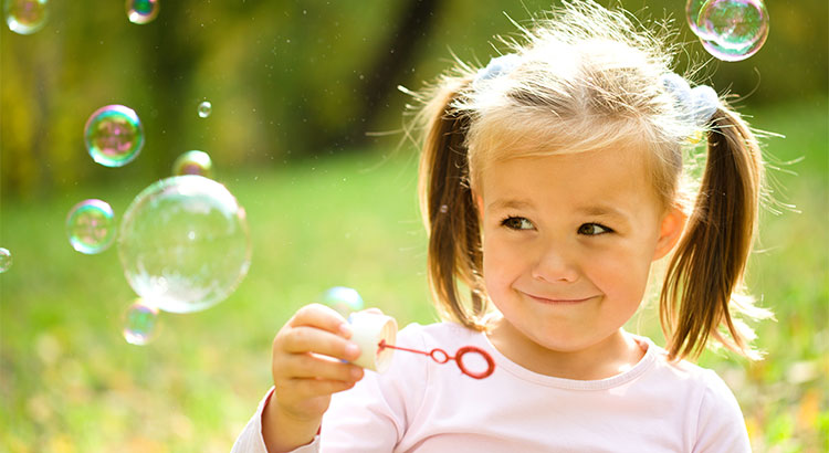 little girl blowing bubbles