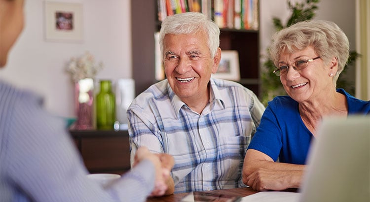 older couple shaking hands with realtor