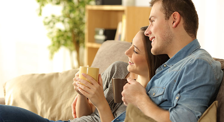 man and woman cuddling on the couch